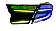Load image into Gallery viewer, Car headlight with RGB lighting on a workbench